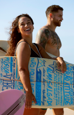 Couple souriant avec une planche de surf colorée