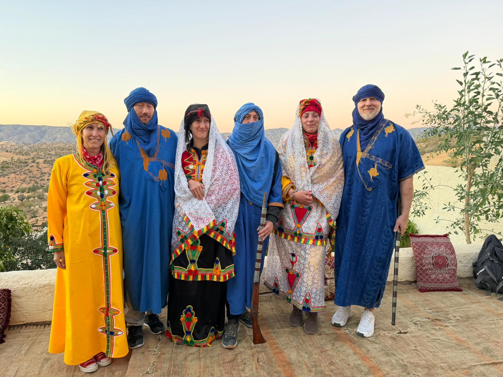 Groupe de voyageurs en costumes traditionnels marocains au coucher du soleil
