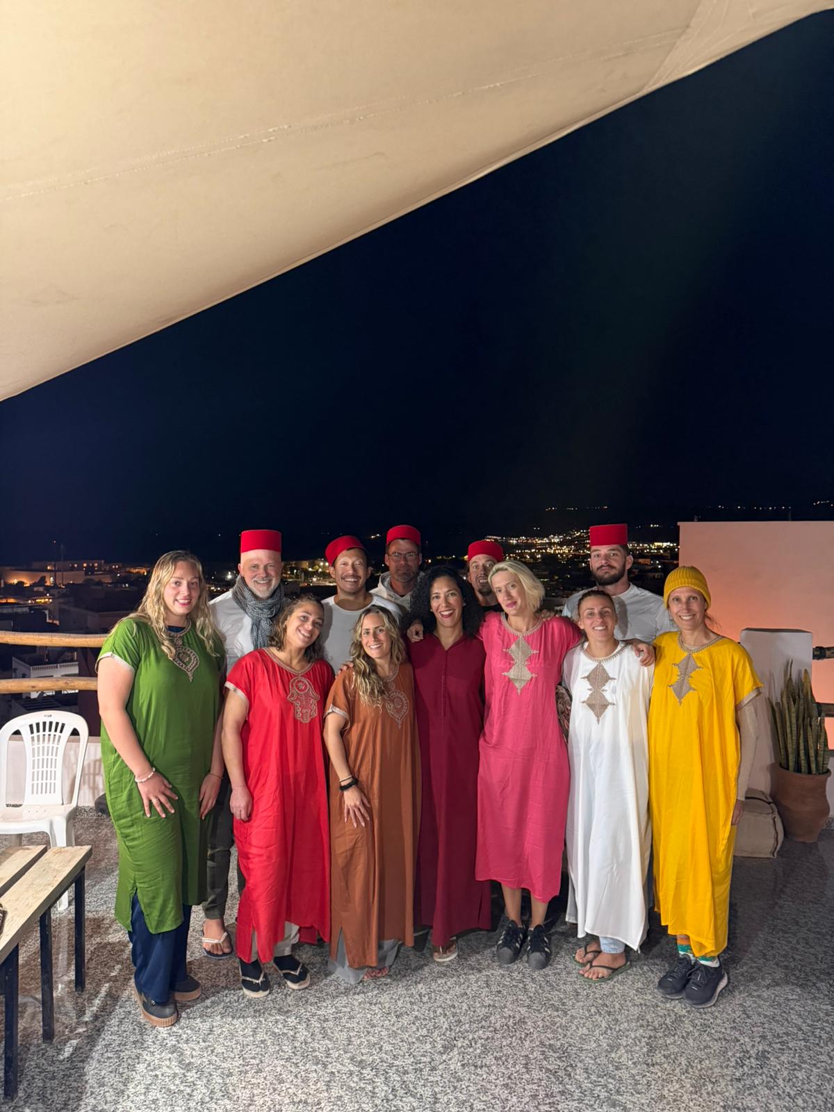 Groupe de voyageurs en tenue marocaine sur un rooftop à Taghazout