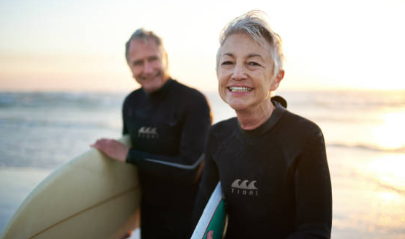 Couple de surfeurs matures au coucher du soleil