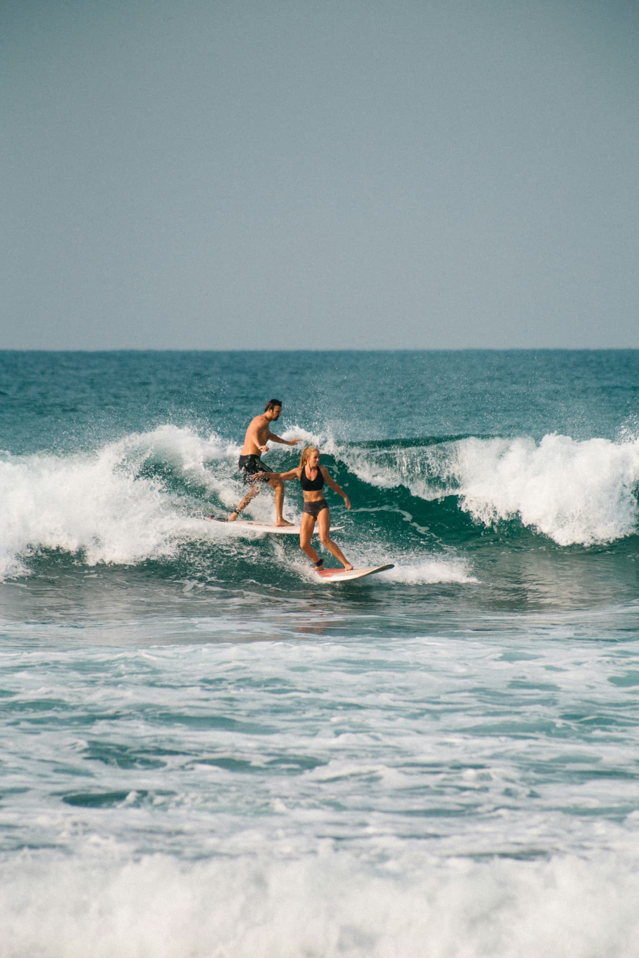 Couple surfant la même vague ensemble
