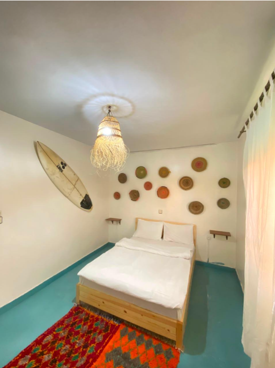 Chambre double avec planche de surf et plateaux berbères