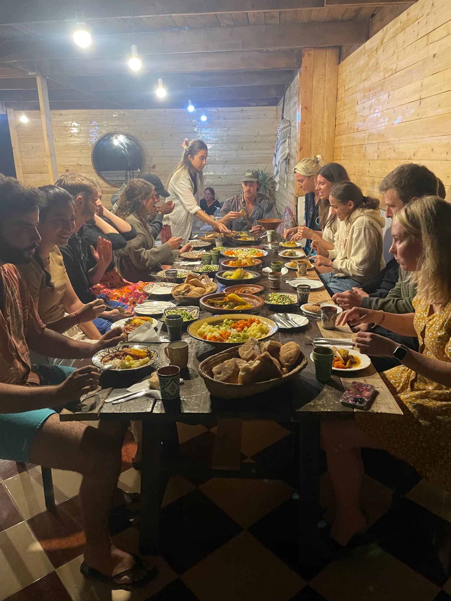 Grande table en bois garnie de tajines dans la salle à manger en bois