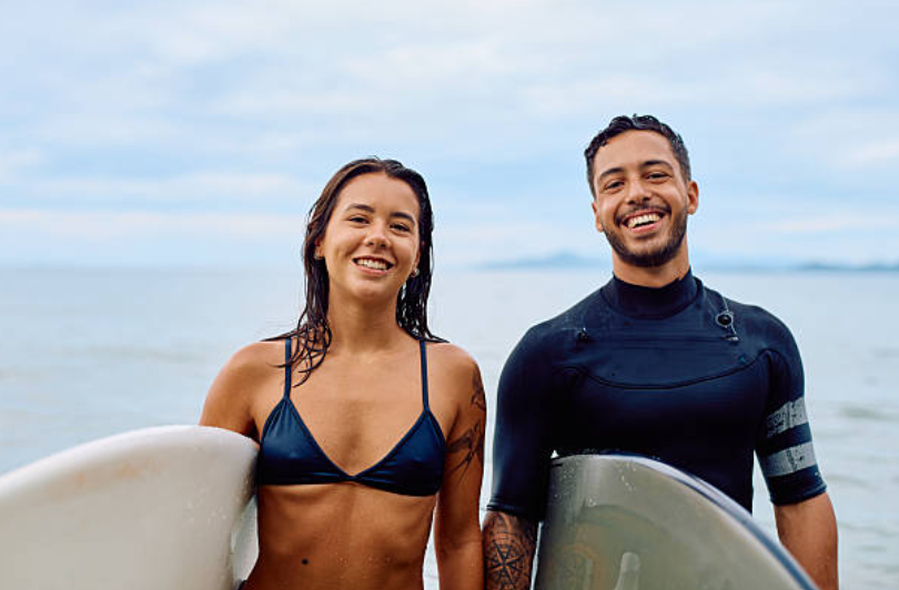 Couple de surfeurs heureux au bord de l'eau