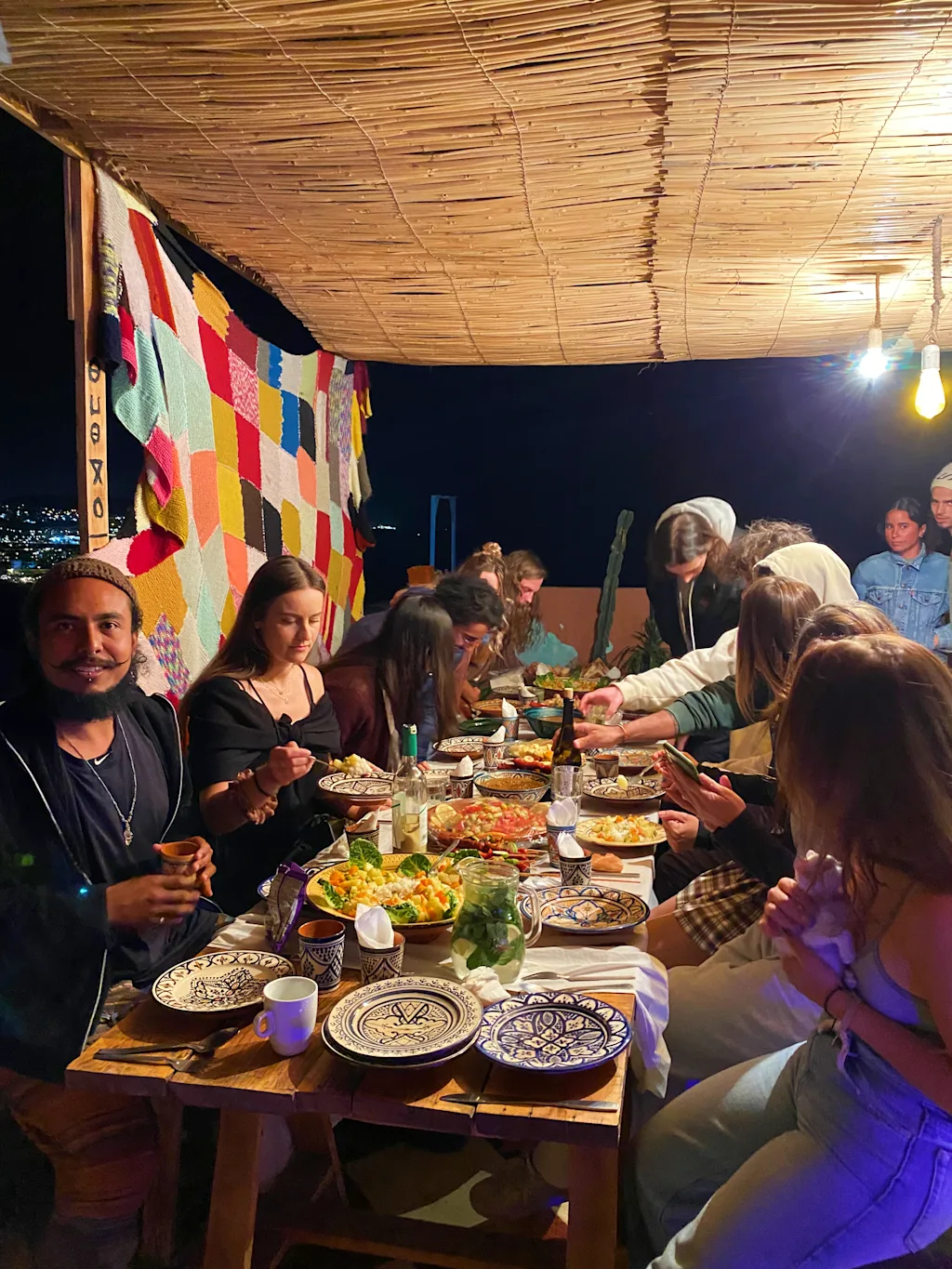 Dîner partagé sous la pergola en bambou avec mur de crochet coloré